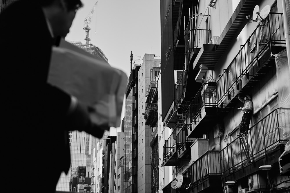A man repaints a building in Tokyo